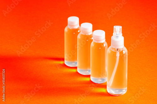 several clear bottles with hydrochloric gel along with a funnel to fill serves to disinfect covid-19's hands top view photo