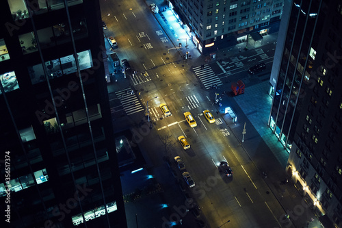 From above of street with vehicles driving among high rise buildings in center of New York city