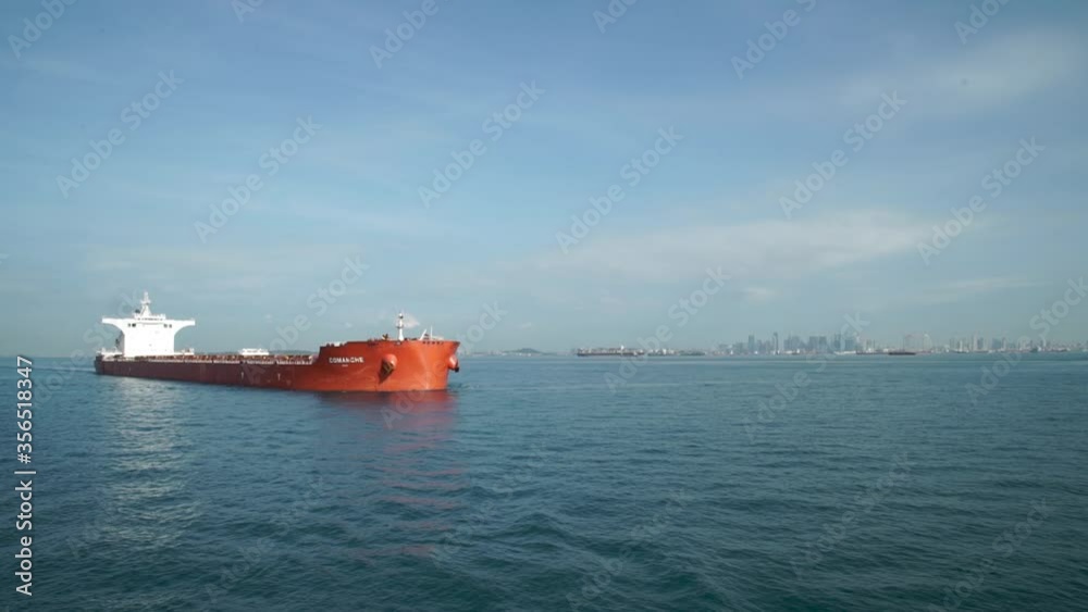 A large cargo ship for transporting goods near the port of Singapore.. A bulk carrier carries cargo across the ocean. Transportation. Delivery. Logistics. A large cargo ship for transporting goods near the port of Singapore.. A bulk carrier carries cargo across the ocean. Transportation. Delivery. Logistics.