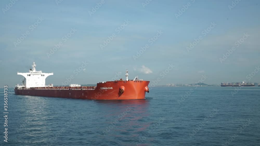 A large cargo ship for transporting goods near the port of Singapore.. A bulk carrier carries cargo across the ocean. Transportation. Delivery. Logistics. A large cargo ship for transporting goods near the port of Singapore.. A bulk carrier carries cargo across the ocean. Transportation. Delivery. Logistics.