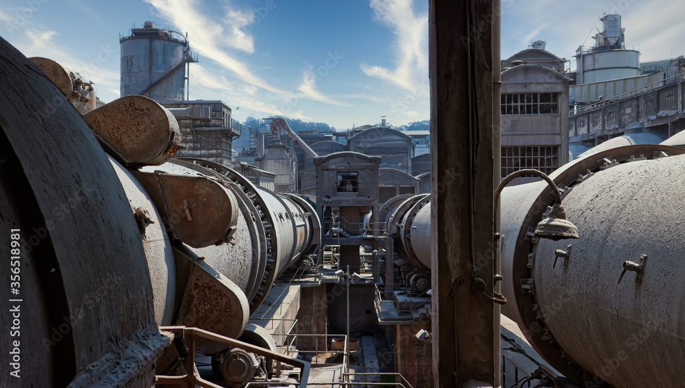 © Inigo Calles/ADDICTIVE STOCK - View of storage aged containers with gas located on territory of industrial area in front of water towers and abandoned construction