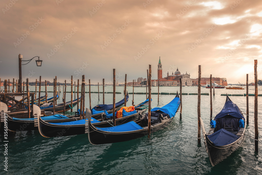 Famous Venetian gondolas in canal. Gondola is hallmark of Venice, Italy.