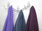 Bathroom. Three towels are hanging on the blue wall. Background for an inscription