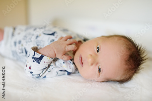 Cute little newborn baby boy lying on a changing table. Portrait of tiny new baby at home.