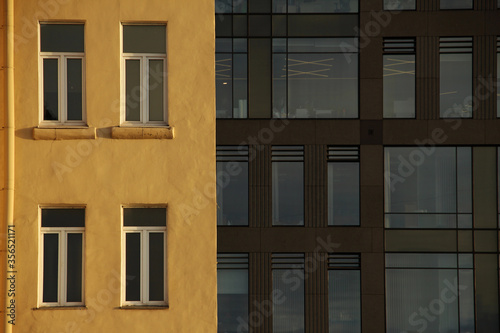 windows of an old building against the background of windows of a modern office building