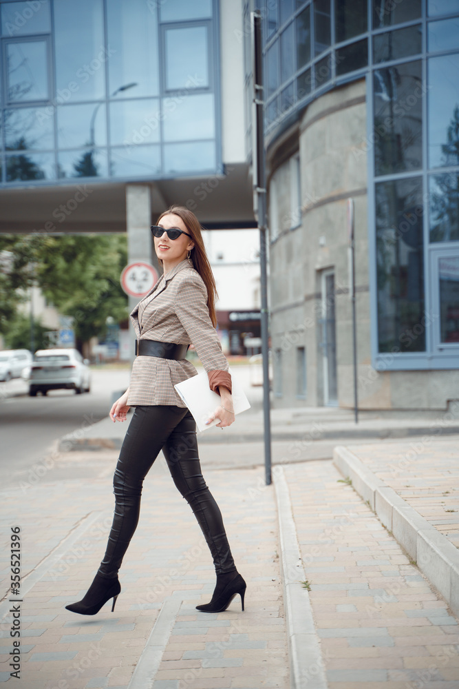 Beautiful young girl in a business suit on a background of business center. Business theme Beautiful young girl in a business suit on a background of business center. Business theme