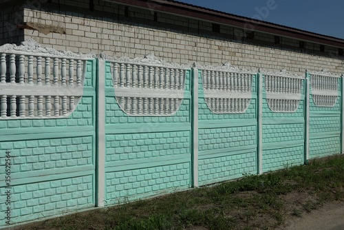 white green wall of concrete fence on a rural street on a sunny day