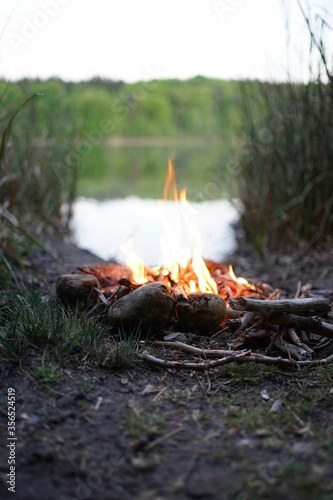 Bonfire at lake campsite at dusk 