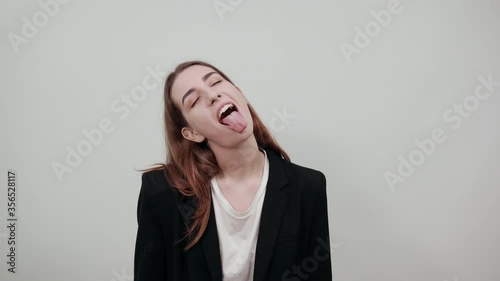 Fooling around outside, sticks out tongue as a sign of disobedience, protest and disrespect. Human emotions, reactions, feelings, attitude, having fun, grimacing healthy oral cavity. Attractive woman