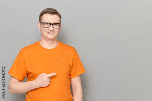 Portrait of happy man pointing with finger at empty place and smiling