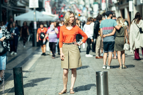 A blond woman in posing standing on the street. Porto, Portugal.