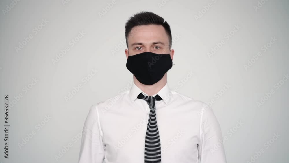 portrait of male wearing white shirt tie and mask. standing on wall background. avoidance of coronavirus, epidemic, spreading. businessman safety and stop prevent coronavirus flu