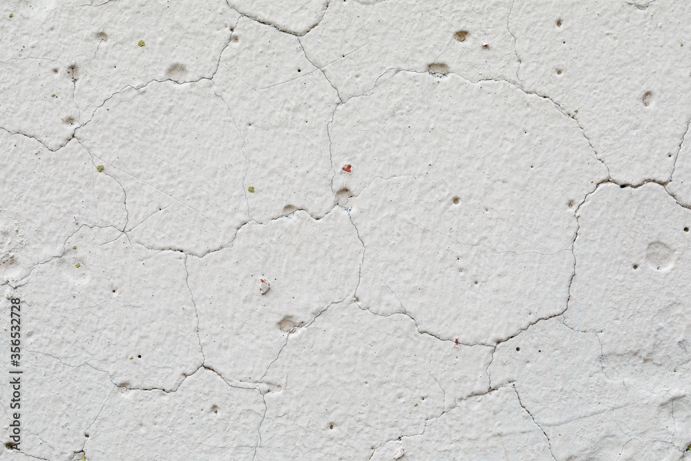 Obraz premium The texture of concrete, an old white wall with irregularities, cracks and potholes. Abstract background.