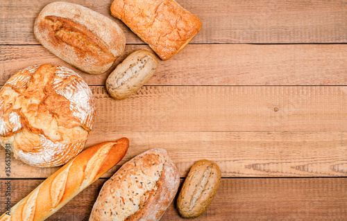 Bakery - various rustic crisp loaves of bread and rolls on wooden boards.