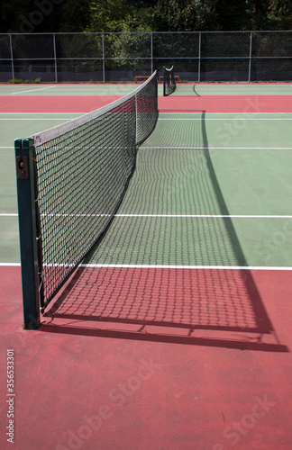 Various angles of green tennis courts with white stripes and nets
