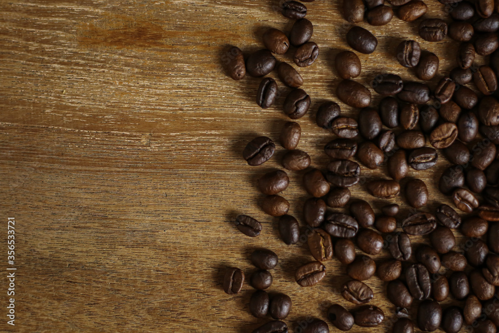 Coffee beans on wooden table with copyspace for text. Selective focus.