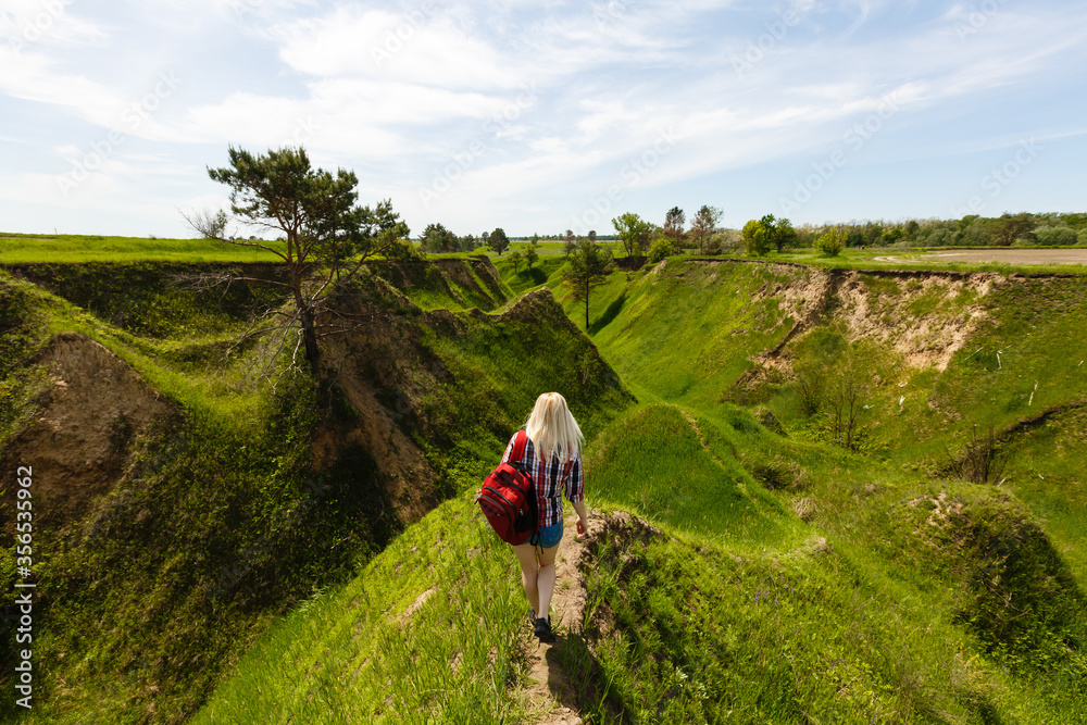 Obraz premium Lifestyle summer image of pretty blonde hipster woman with bag pack traveling and enjoying, stylish fresh look, happy mood, sunny colors, travel concept, emotions.