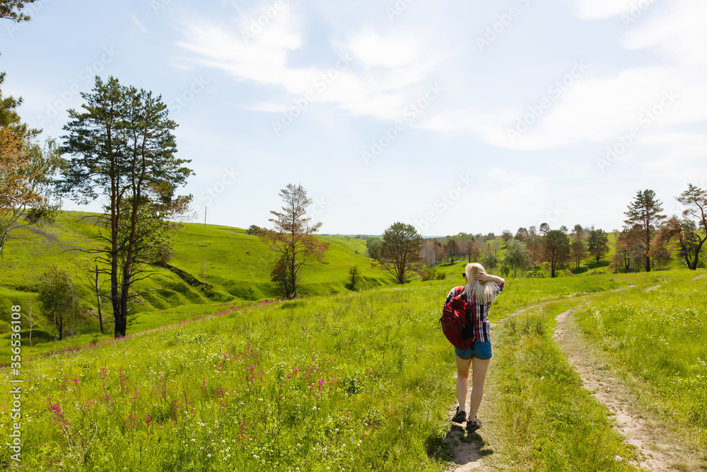 Lifestyle summer image of pretty blonde hipster woman with bag pack traveling and enjoying, stylish fresh look, happy mood, sunny colors, travel concept, emotions.