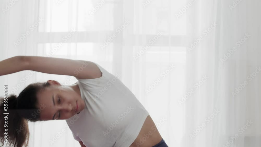 Close up of young sporty african american woman practicing stretching at home