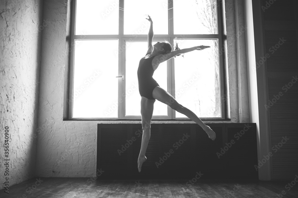 Plasticity slim woman dancing near window. Professional dancer enjoy dance. Lady Dancer Training Modern Ballet In Class. Contemporary dance performer. Daylight, silhouette beautiful body. Dance theme