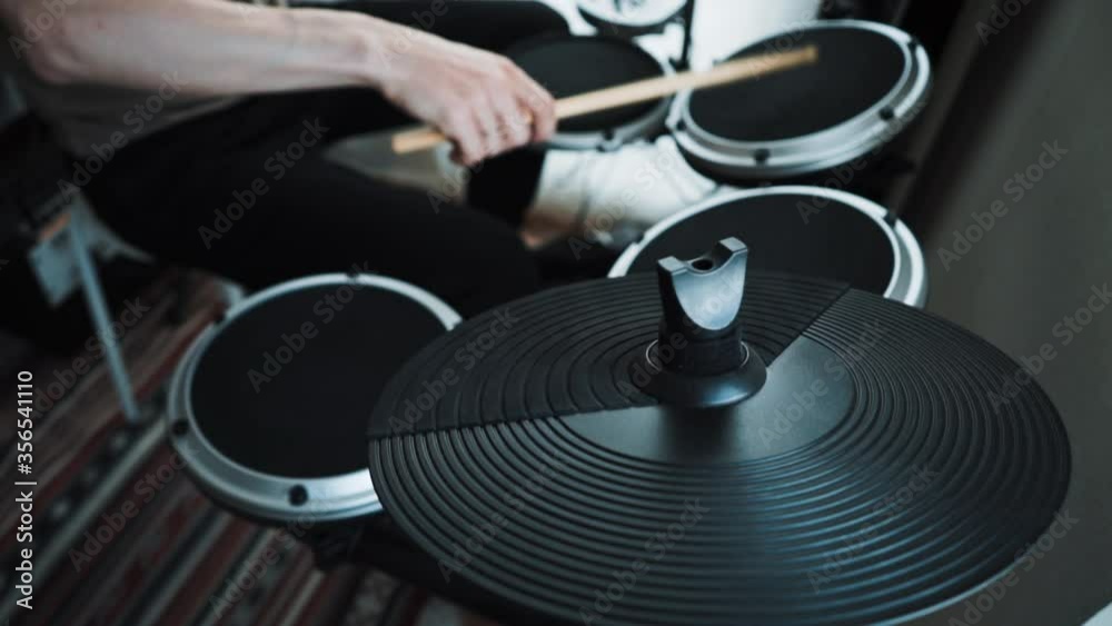 Young male drummer playing electronic drum kit at home. Rock music performance. Percussion instruments lesson in 60 fps can be in slow motion
