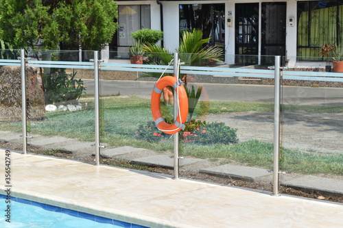 Flotador salvavidas al lado de la piscina, listo para usar cuando sea necesario.