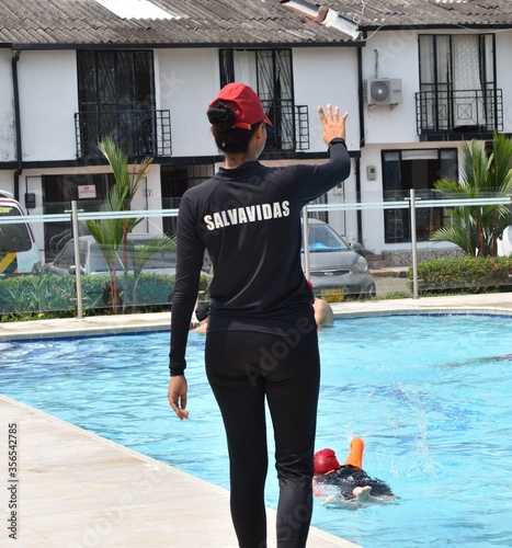 La socorrista de una piscina recreativa da instrucciones de seguridad al nadador.