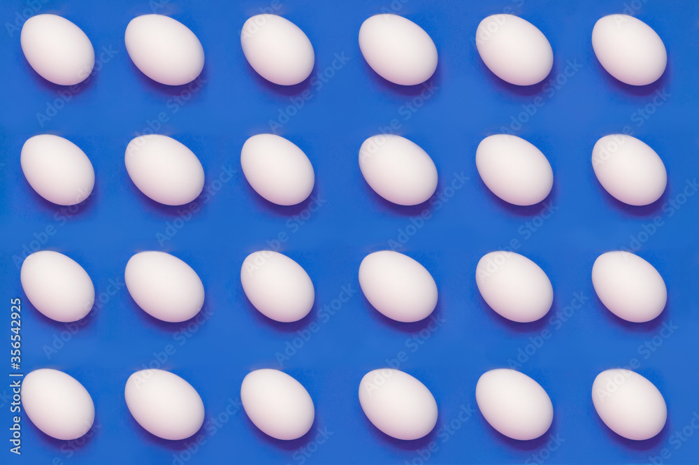 White eggs arranged on solid color background
