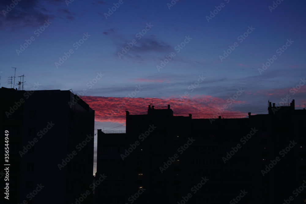 Night view of modern residential architecture and the city  with beautiful pink sunset and cloudy sky