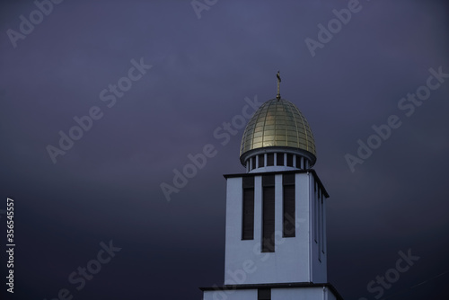 Golden-domed church towers with crosses against dramatic blue and purple twilight skies, highlighting architectural beauty and spiritual symbolism