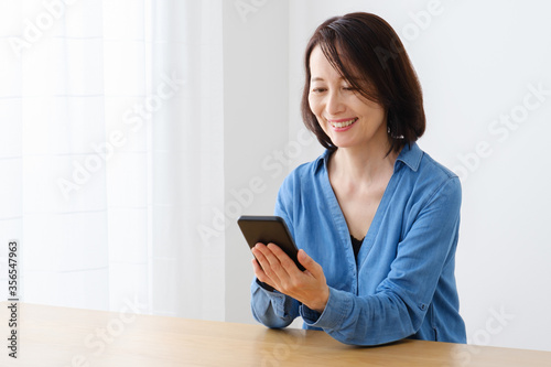 Fotografie スマートフォンを使う中年女性