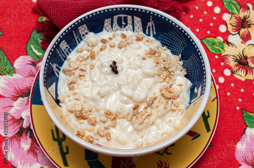colorful bowl of tasty hominy, brazilian canjica, with peanuts, clove and cinnamon. Typical brazilian june party food.