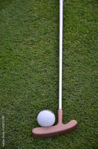 golf ball and golf club on green