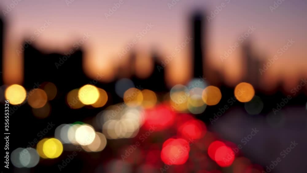 Beautiful glittering bokeh in dark blurry background at night. The round colorful bokeh shine from car lights in traffic jam on city street. Out of focus with blurry. Unfocused city lights. Traffic.