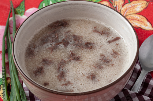 tasty cassava soup with meat on colorful table