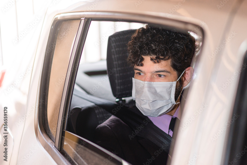 Businessperson using protective mask in car service.