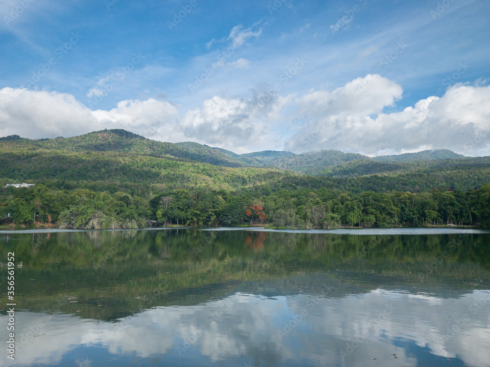 Fresh green mountain reflection in freshwater lakeside 