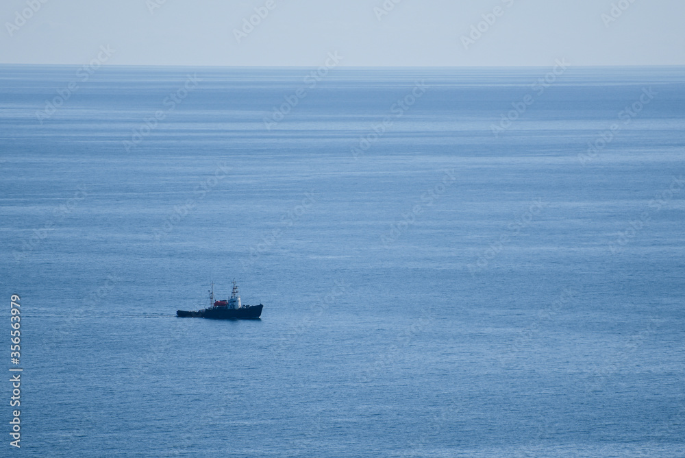 The same boat sailing in the calm blue sea
