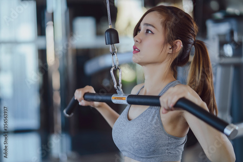 fitness new normal, Woman at the gym on a sports simulator., Fit beautiful young woman exercise workout on machine in gym. Glad smiling girl is enjoy with her training process. Concept of fitness, Hea photo