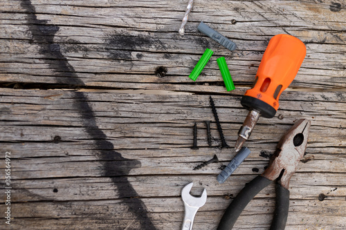 Hand tools on aged wood, screws, screwdriver, dowels, mixed wrench