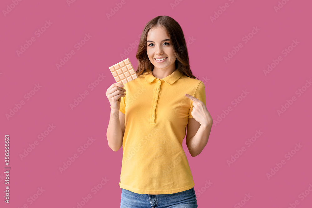 Beautiful young woman with tasty chocolate on color background Beautiful young woman with tasty chocolate on color background