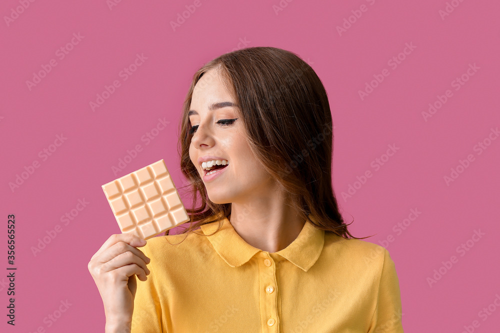 Beautiful young woman with tasty chocolate on color background Beautiful young woman with tasty chocolate on color background