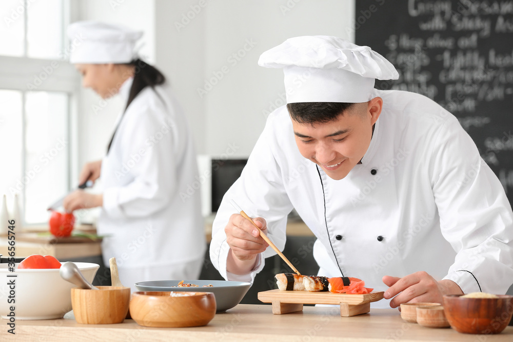 Handsome Asian chef cooking in kitchen Handsome Asian chef cooking in kitchen