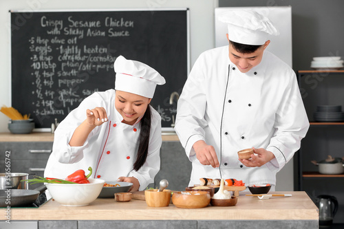Asian chefs cooking togethe...