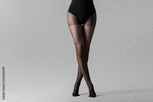 Beautiful young woman in tights on grey background photo