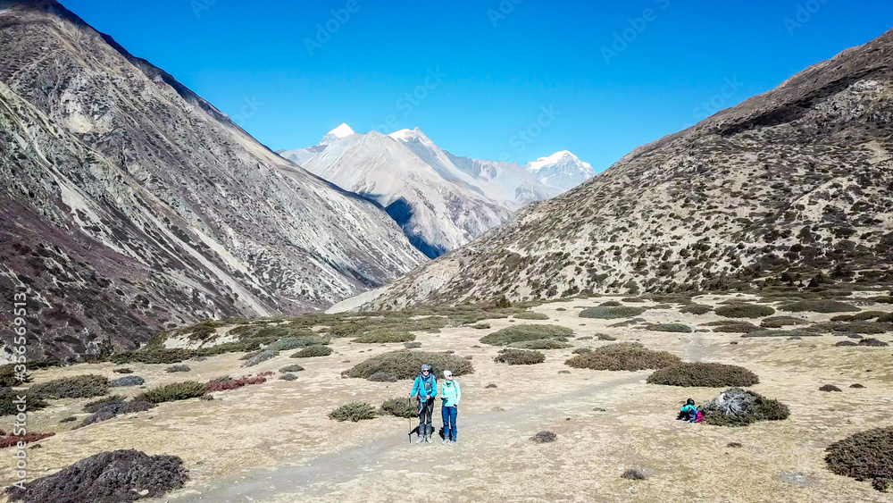 Φωτογραφία A couple trekking in the Manang Valley, Annapurna Circus Trek, Himalayas, Nepal, with the view on Annapurna Chain and Gangapurna