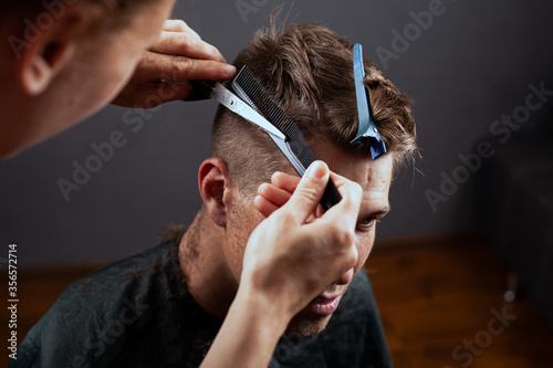 fashion haircut, young guy cuts hair at the hairdresser. barbershop