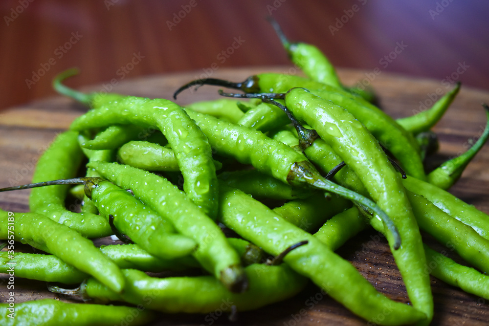 fresh green chilies on chopping board for spicy vegetable fresh green chilies on chopping board for spicy vegetable