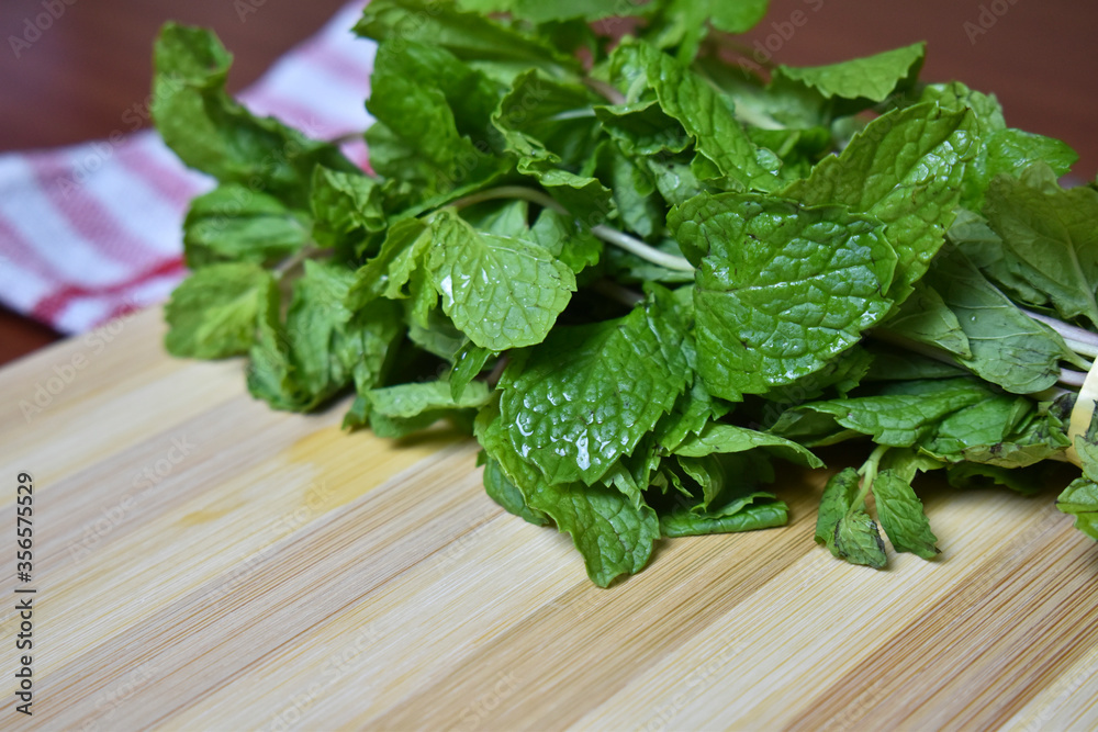 fresh mint leaves on wooden chopping board fresh mint leaves on wooden chopping board