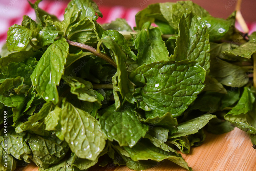 fresh mint leaves on wooden chopping board fresh mint leaves on wooden chopping board